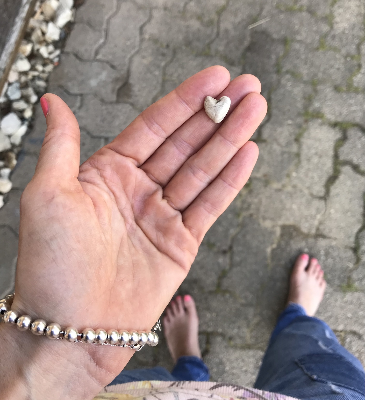Das Bild zeigt die Hand von Natalie mit einem Stein darauf, der aussieht wie ein kleines Herz.